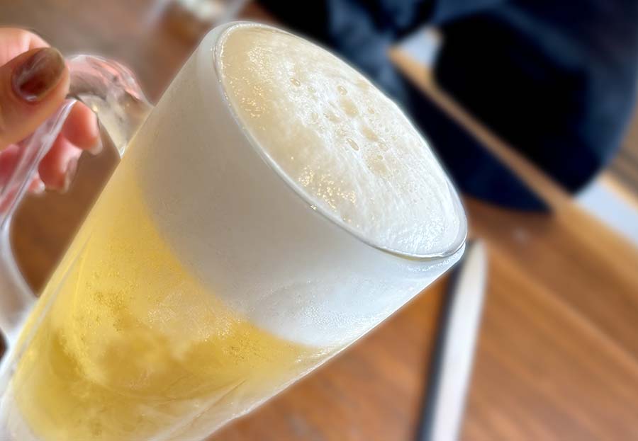 ジョッキに注がれた生ビールと中華料理のテーブル風景