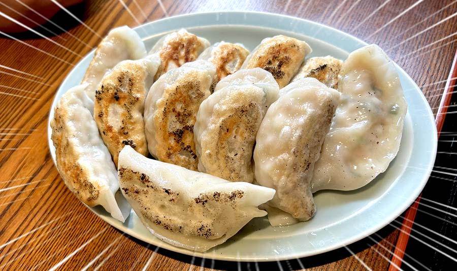 焼き目がしっかりついた餃子二人前が並んだ皿